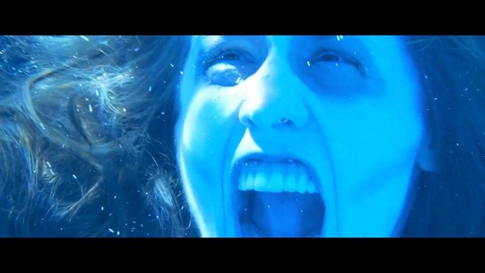 Acting 3 professional Actress Shannon Scott submerged underwater during a dramatic movie scene, her hair flowing around her face as light filters through the water above.