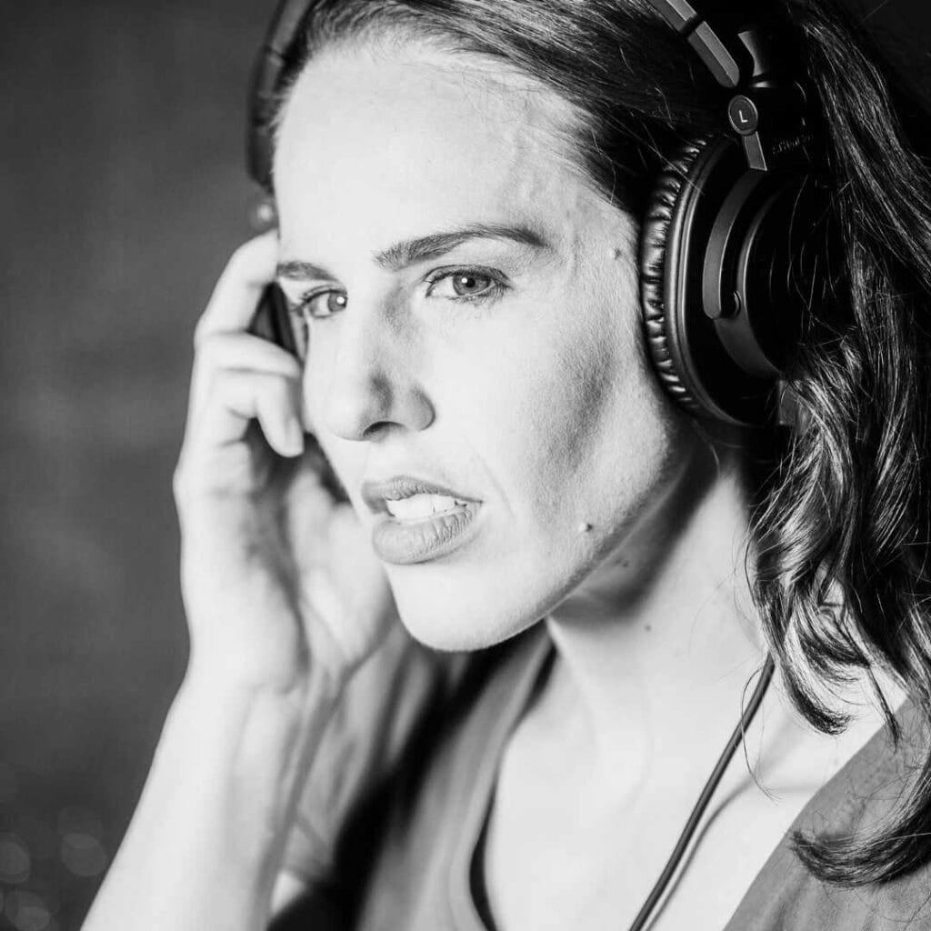 Female voiceover artist listening in headphones for source connect session