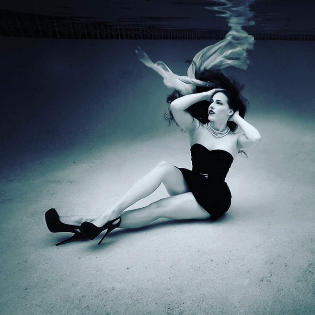 girl sitting on the bottom of a pool looking up