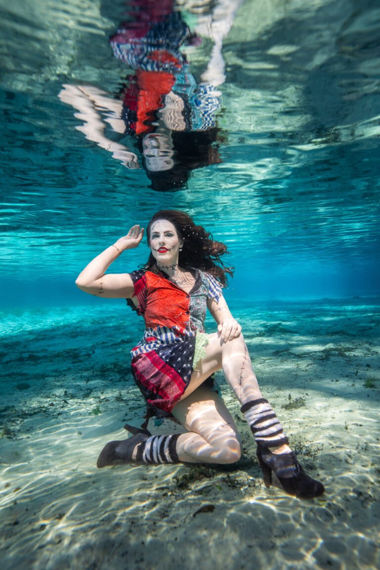 a woman dressed as sally from the nightmare before christmas in a dress underwater