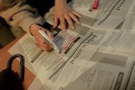 So You Want to Be a Voice Actor? Here’s What You Really Need to Know 6 An adult woman highlights job ads in a newspaper, focusing on employment opportunities.