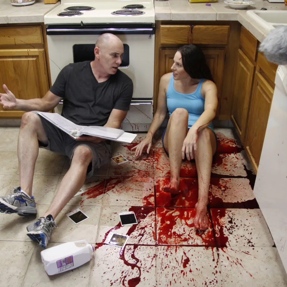 On-camera actress Shannon Scott behind the scenes with a director on a film set during a special effects scene