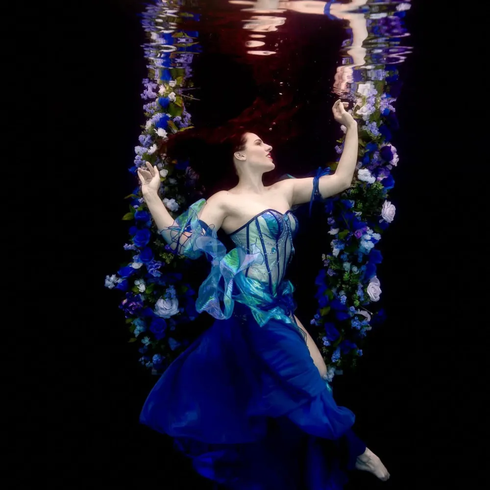 Fashion-forward underwater modeling photo of Shannon Scott posing gracefully in flowing wardrobe, part of her professional underwater modeling portfolio.