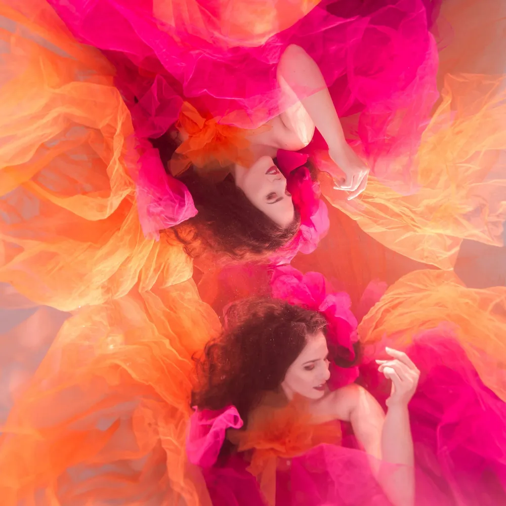 Underwater Photoshoot Safety: How to Prepare for a Successful Shoot 5 Underwater model Shannon Scott posing gracefully beneath the surface in a flowing pink and orange dress.