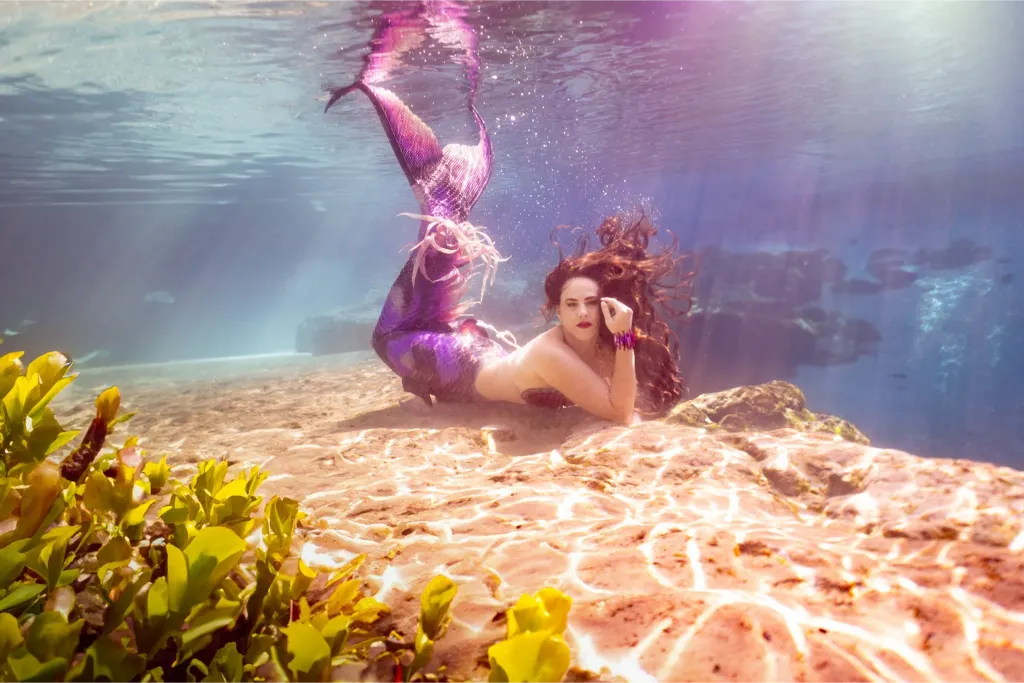 Real-life mermaid Shannon Scott poses gracefully underwater in the crystal-clear Florida springs, showcasing elegant movement and ethereal beauty for a professional modeling shoot.