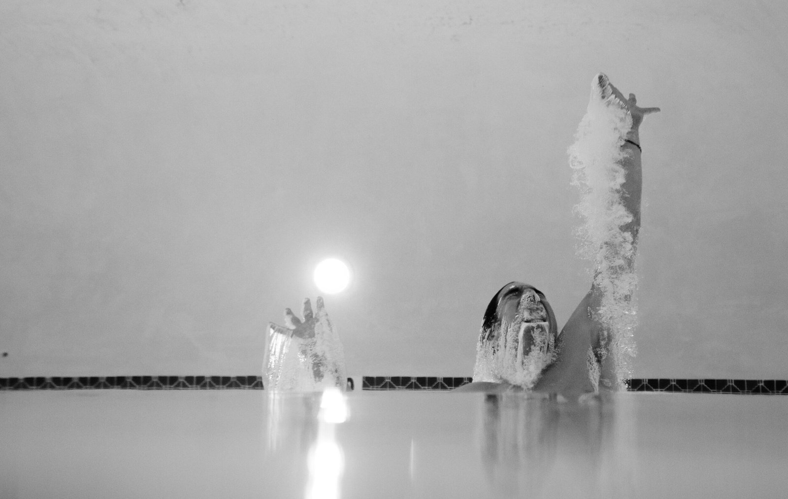 How to Overcome Imposter Syndrome as a Creative: 5 Powerful Exercises for Actors & Artists 4 Captivating black and white photo of a swimmer emerging with water splashing dramatically.