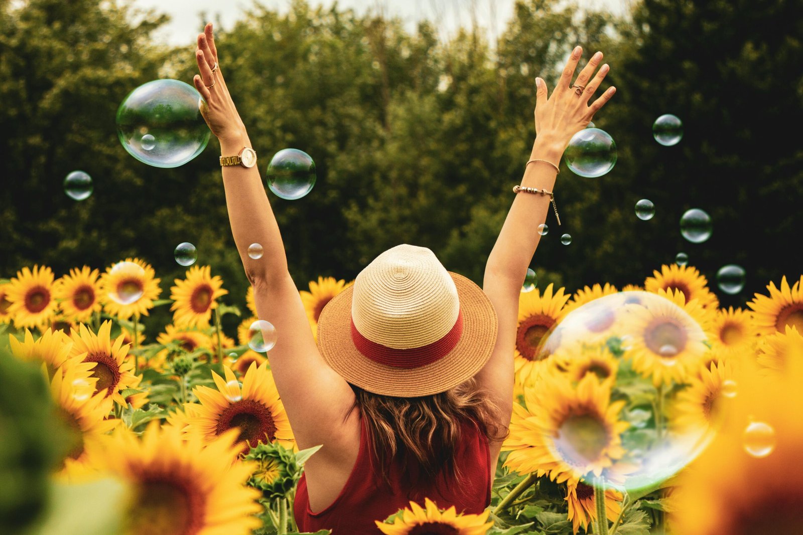 A woman stands in a field of flowers surrounded by floating bubbles, embodying the magic of trusting the process.