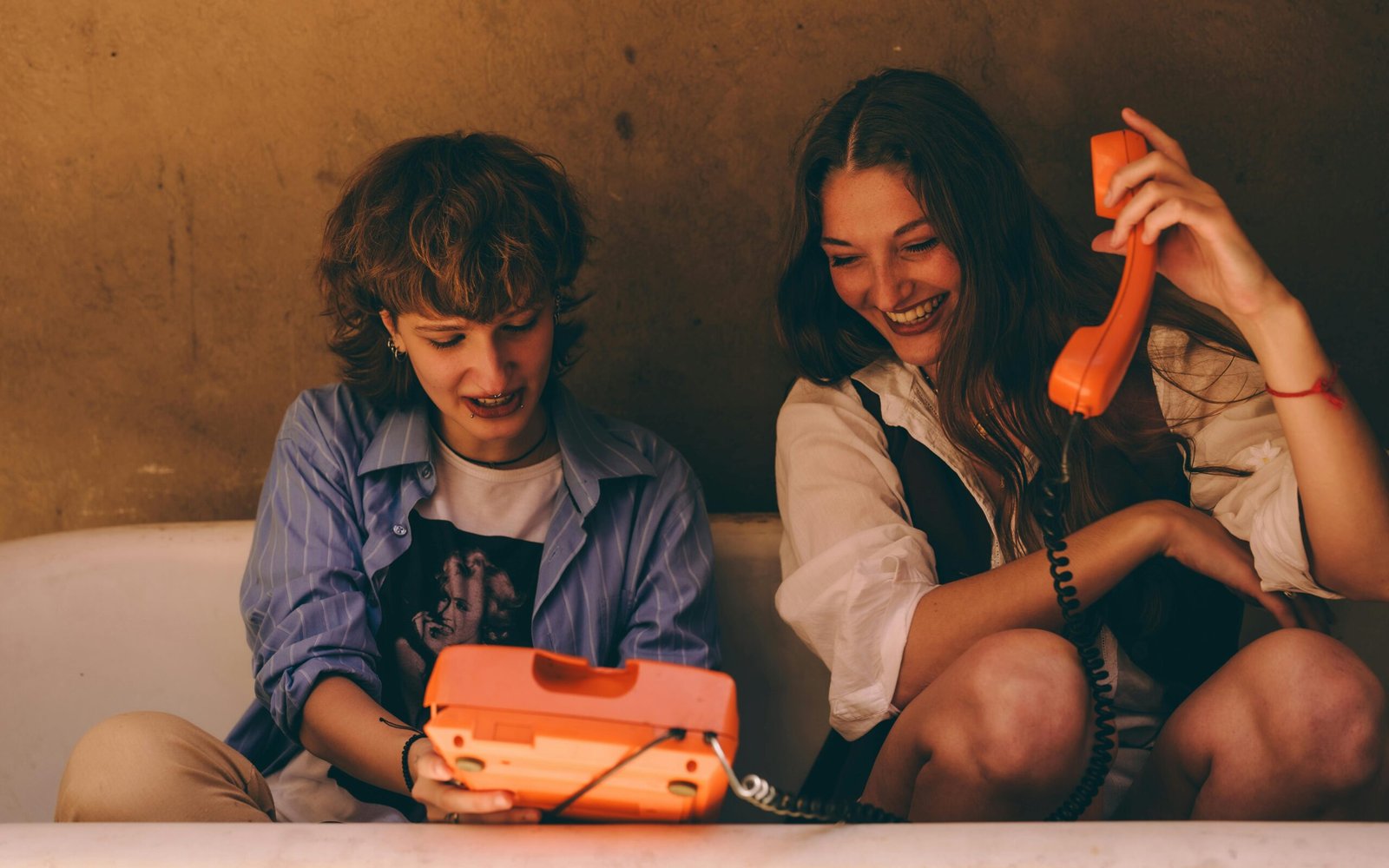 About 9 Girls making a call on an orange retro phone with “Get in Touch” written