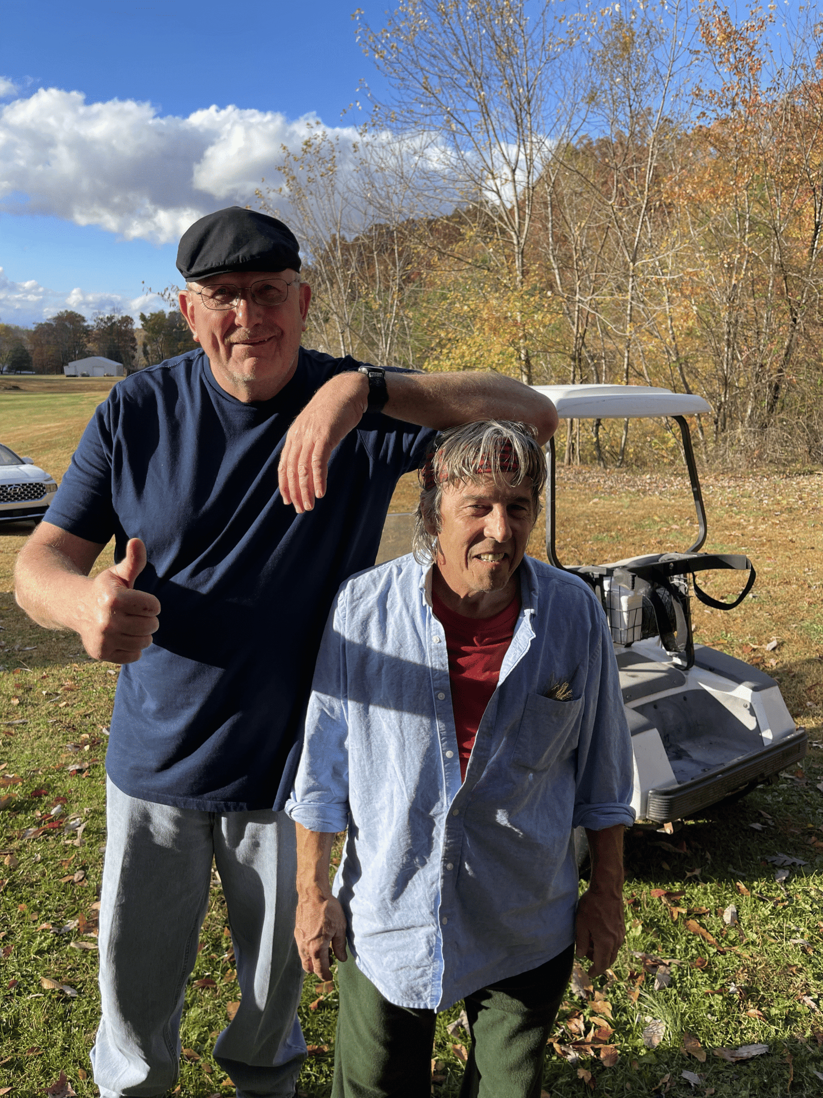 Tom Scott and Curtis Stark on set of Eddie’s Trailer Park, Curtis towering and resting arm on Tom’s head