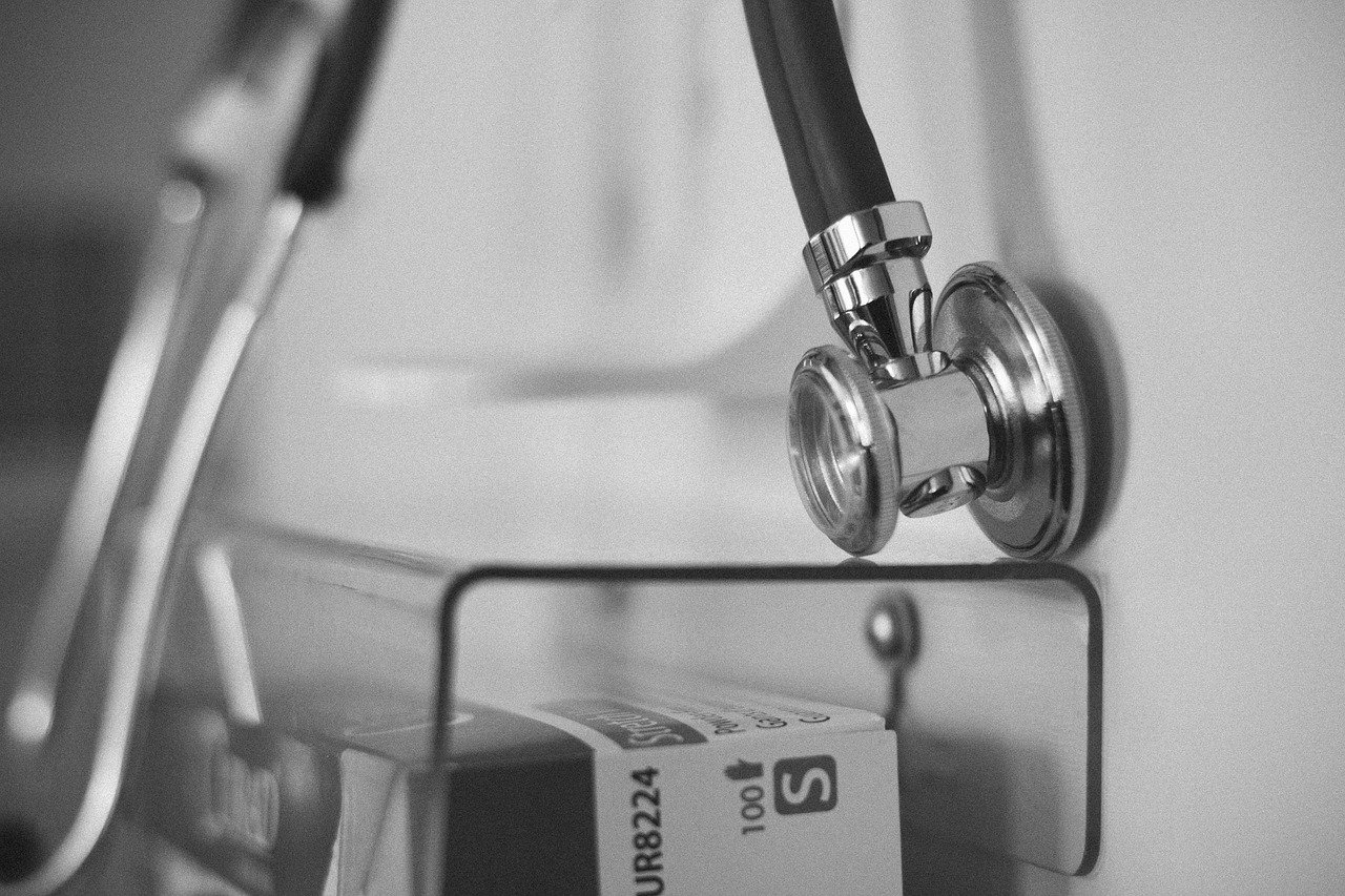 Black and white stethoscope hanging in a calm, minimal medical setting representing healthcare and medical communication