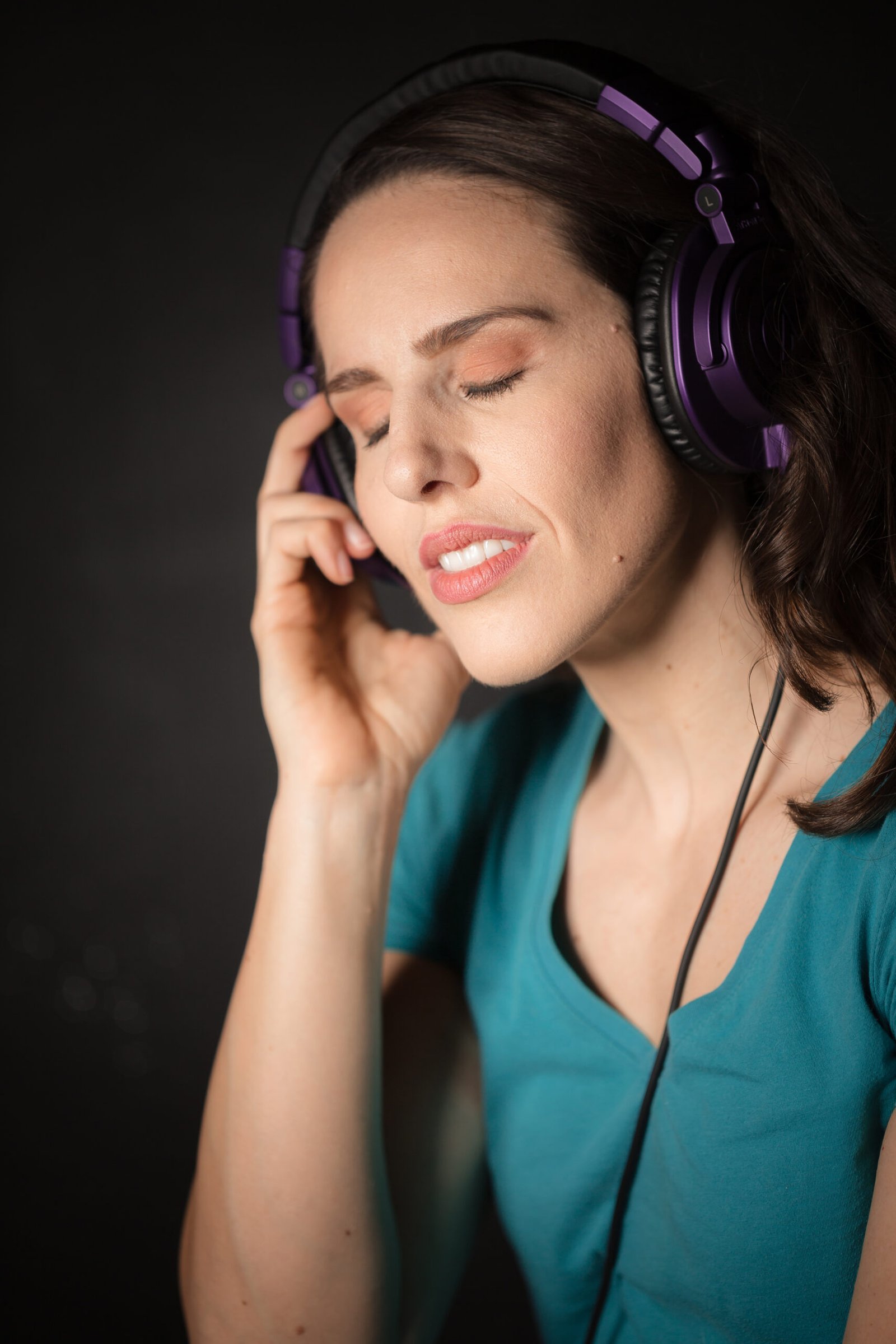 Voice actor listening to audio through headphones with eyes closed during a focused medical voiceover recording session