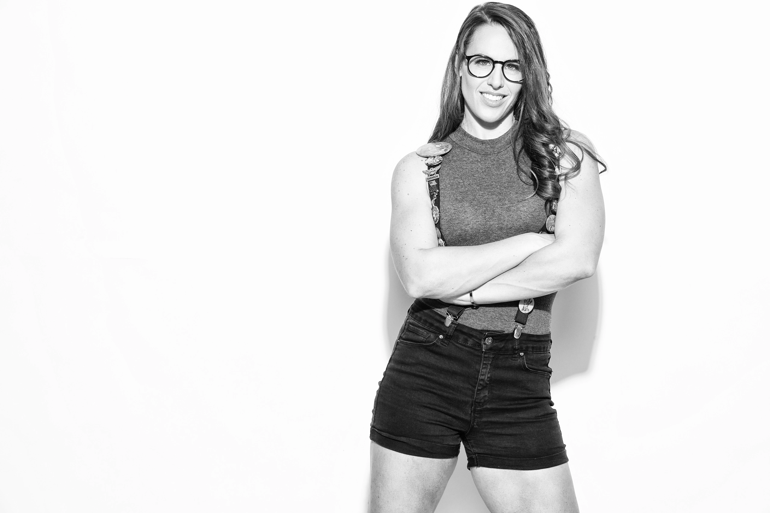 Confident female voice actor standing with arms crossed in black and white portrait