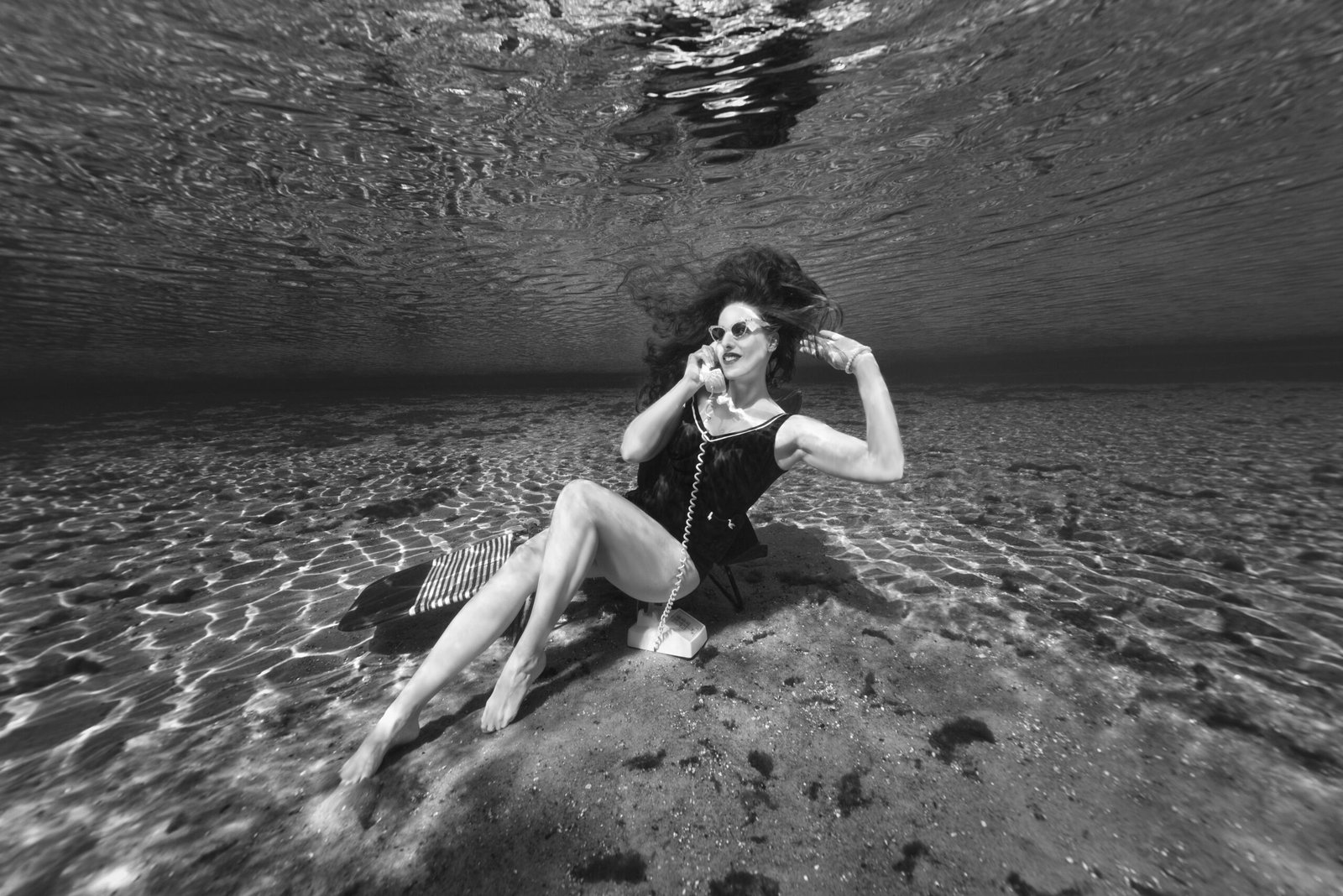 Professional underwater model Shannon Scott on vintage phone call underwater black and white