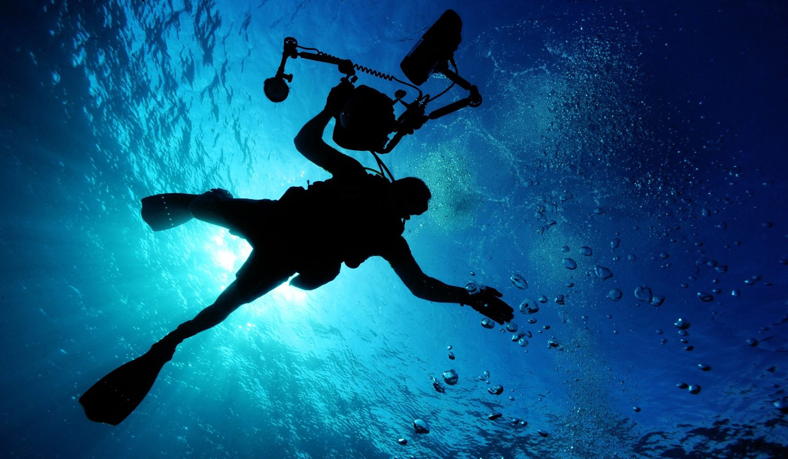 Underwater Photoshoot Safety: How to Prepare for a Successful Shoot 4 Silhouette of a diver holding an underwater camera during an underwater production shoot.